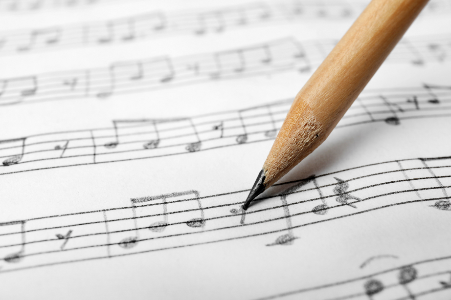 visuel crayon à papier écrit sur une partition de musique